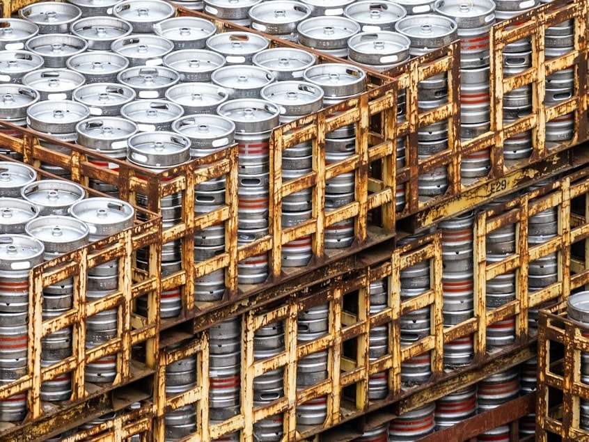 Crates of aluminium beer kegs stacked in a depot